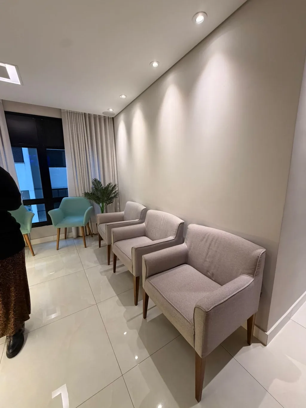 Corredor da clínica, com as poltronas de espera ao fundo
