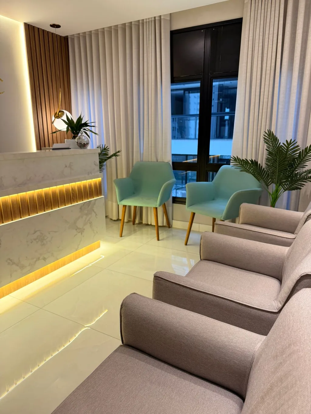 Sala de espera da clínica, com poltronas e iluminação indireta